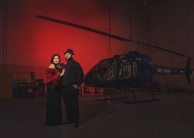 couple posing with helicopter during engagement shoot in Mesa Arizona